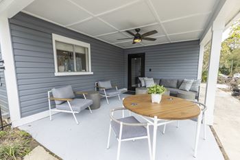 a patio with a table and chairs and a ceiling fan